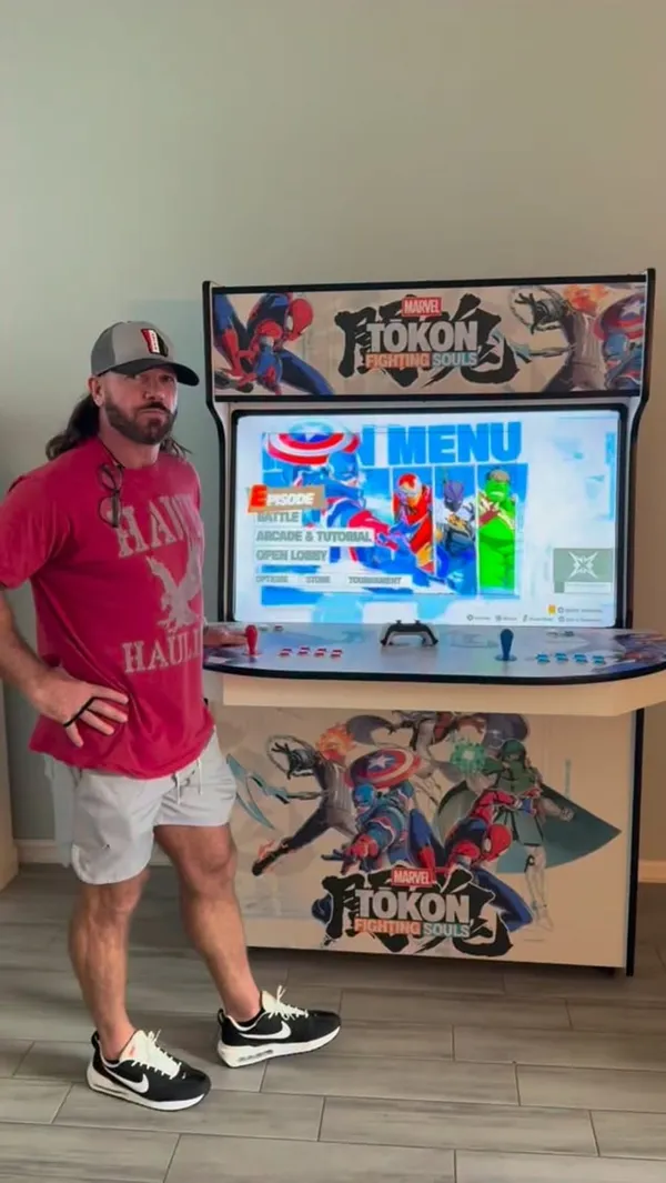 AJ Styles standing beside his Phantom Evolution with Marvel Tōkon on screen